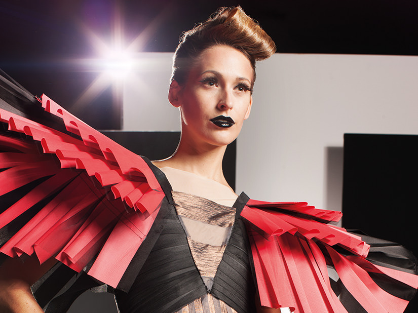 Model in einem Haute-Couture-Kleid mit roten Plissee-Elementen von Marcell von Berlin für JalouCity